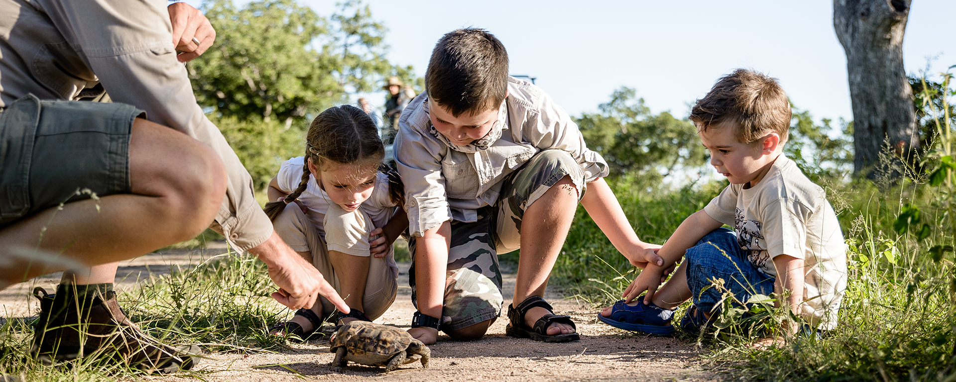Children soak up the ranger's wilderness wisdom & embrace new experiences, like meeting creepy-crawlies!