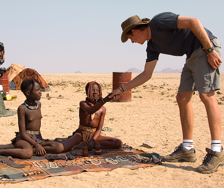A traveller meets Himba girls - one has begun her passage to womanhood and is adorned with the ochre mixture that reddens her skin.