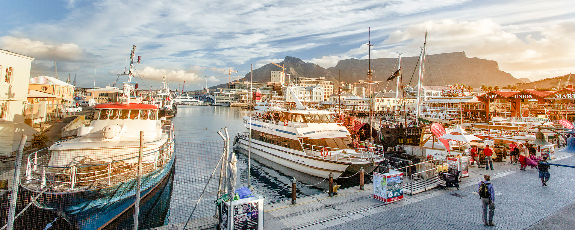 The V&A Waterfront in Cape Town is a thriving shopping & entertainment hub that has unfettered views of Table Mountain.