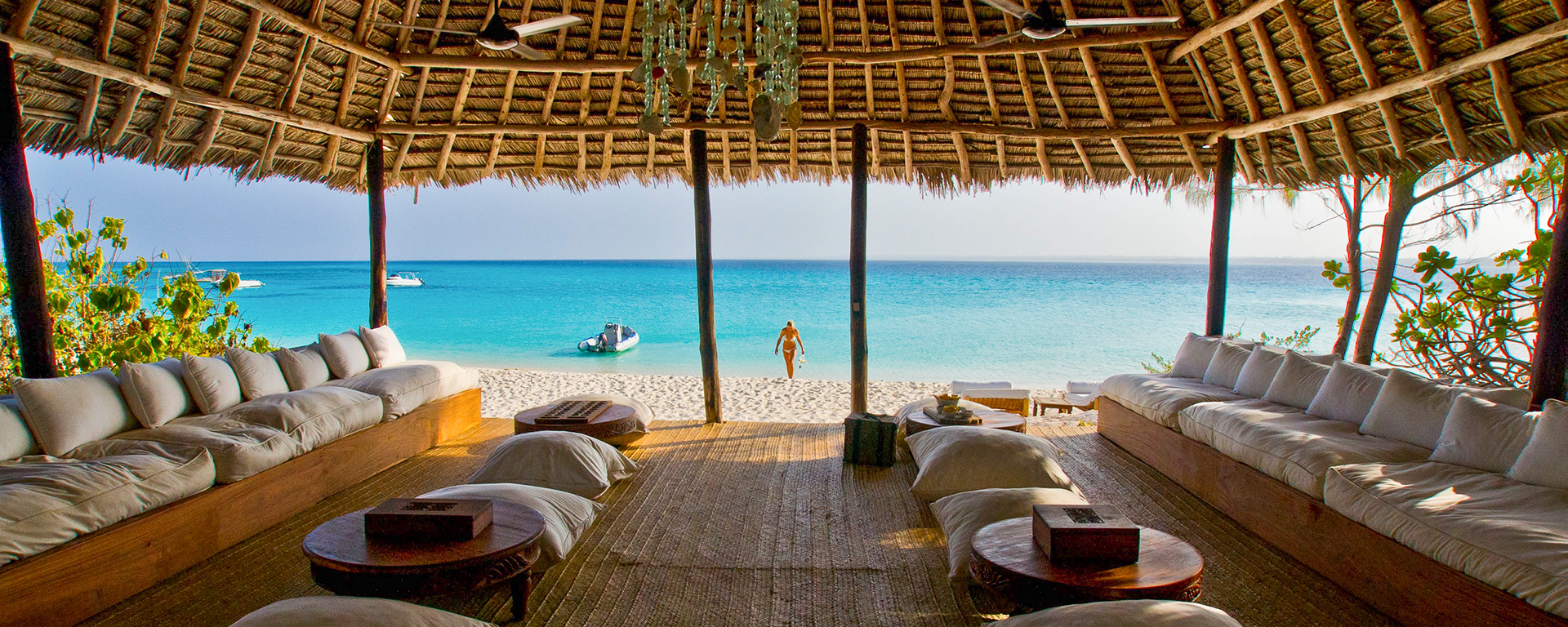 Drift effortlessly between the shady beach lounges and the sun-kissed surf at Mnemba Island Lodge in tropical Zanzibar.