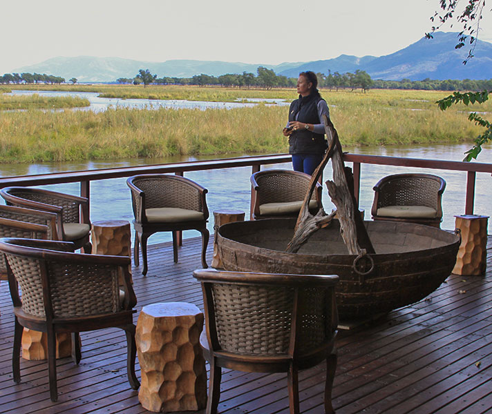 Safari Expert Natasha watches chortling hippos from the expansive deck at Sausage Tree Camp.