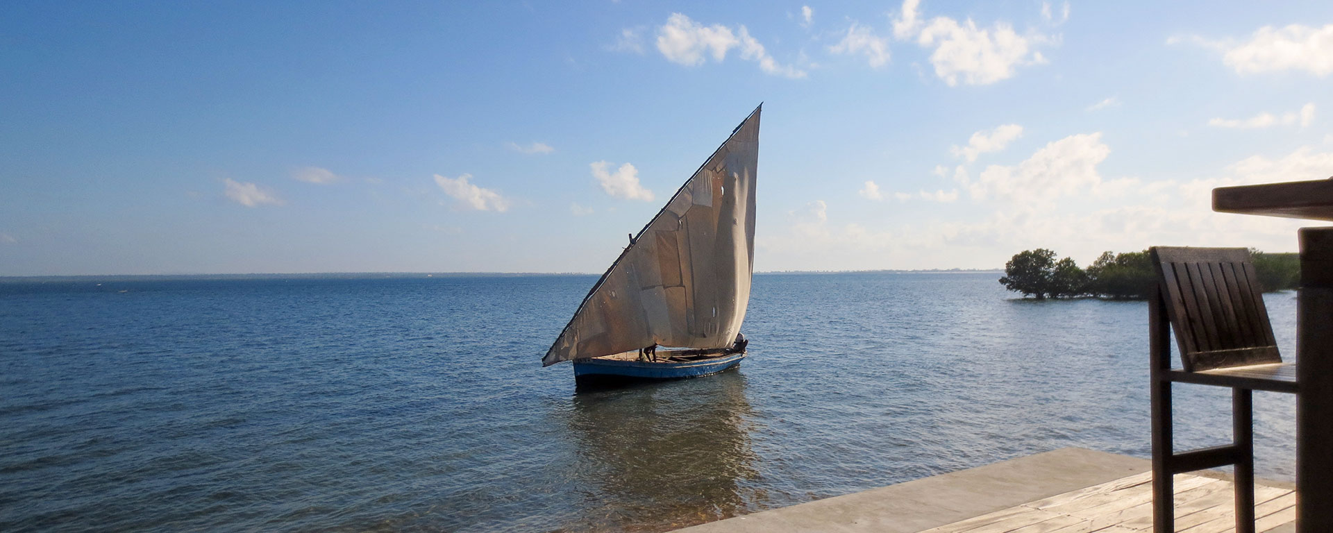 A dhow sails serenely past the beach bar at Villa Sands – note the picturesquely patched sails.