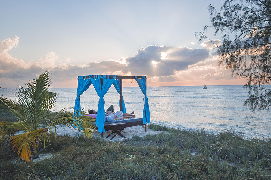 Couple relaxing in a Sala on the beach in Mozambique.