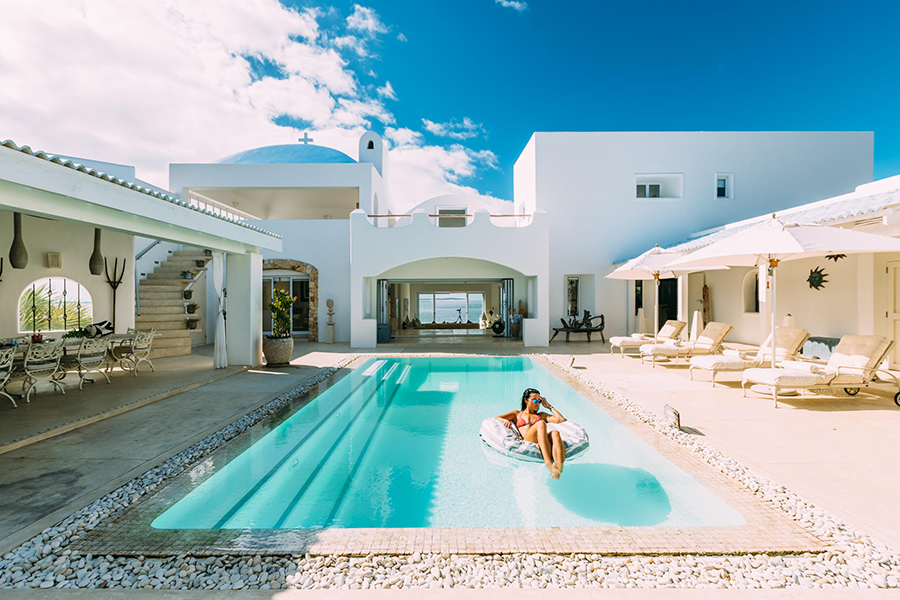 Woman lounges in the pool in the courtyard of Santorini in Vilanculos, Mozambique.